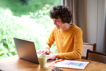 smiling woman working with laptop at home