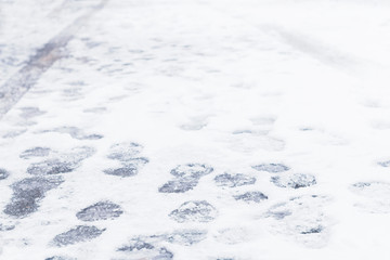 Traces of shoes and tires on a snowy road