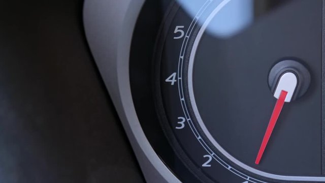 The arrow of a tachometer is moving, increasing to a middle value of the engine speed, driving a car concept with copy space