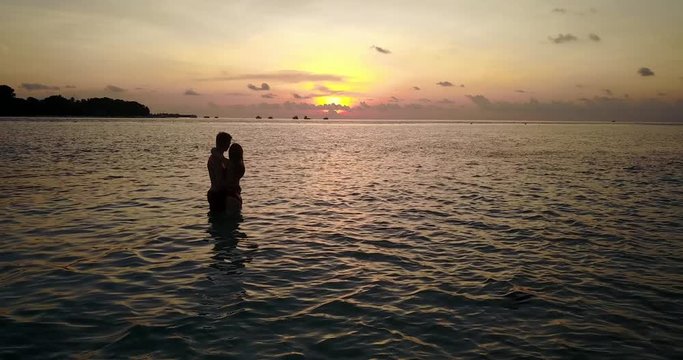 Lovers Kissing In The Sea At Sunset dolly in shot