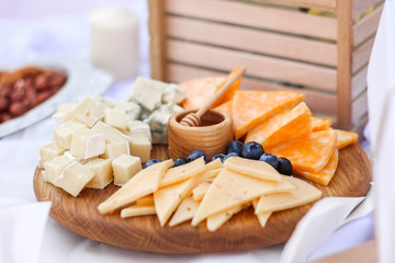 Assorted cheeses with honey and nuts. On a wooden table