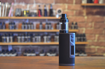 Electronic cigarette on a background of vape shop. E-cigarette for vaping. © Nasibli