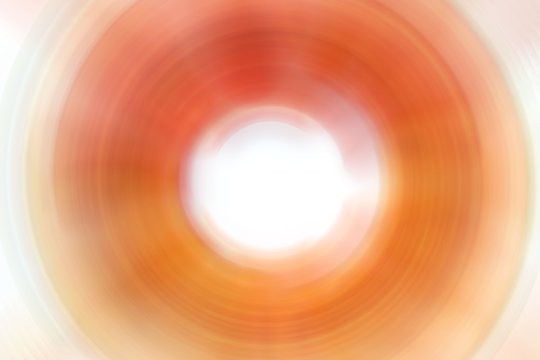 Yellow-orange abstract background in the shape of a circle. Autumn warm shades. Blurred spots, streaks. Design background, back surface.