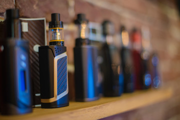 Electronic cigarette on a background of vape shop. E-cigarette for vaping.