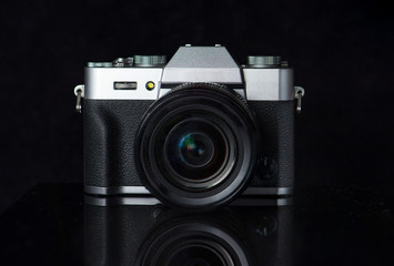 Mirrorless camera on a black background.