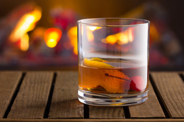 Old Fashion cocktail on fireplace background