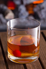 Old Fashion cocktail on fireplace background