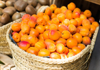 appetizing apricots in wicker baskets on counter in market