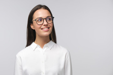 Portrait of young lady dressed in white shirt and wearing glasses looking to right side, copyspace