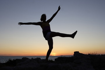 Fototapeta na wymiar evening, sunset, silhouette of a girl against the sea