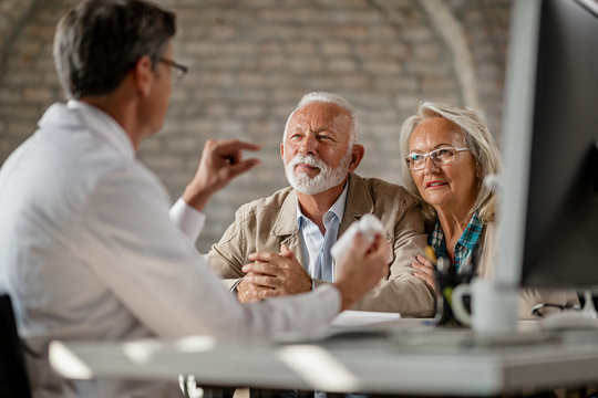 Mature Couple Talking To A Doctor About Supplement Plans During A Meeting.