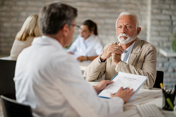 Mature man having consultations with a doctor about his health insurance.