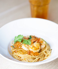 Prawn spaghetti. Pasta with shrimp and salty egg sauce in fusion food style mix of European and Asian style. Soft focus on the prawn.
