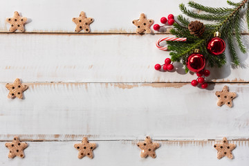 Christmas background concept. Top view of Christmas decoration, glitter star ,red balls with spruce tree branches, pine cones, red berries on old white wooden background with copy space for text.