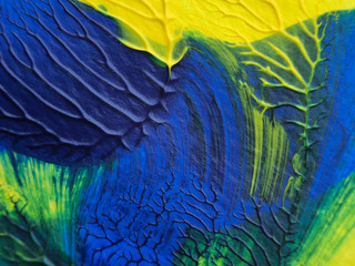 Obraz premium The acrylic painting with blue, green and yellow color texture on white paper background by using rorschach inkblot method.