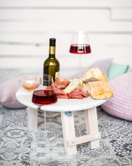 A folding legs tray table is on the bed, red wine in two glasses, blue cheese, camembert, brie, jamon, ciabata, surprise, breakfast in bed, a gift for Valentine's day, birthday, nobody