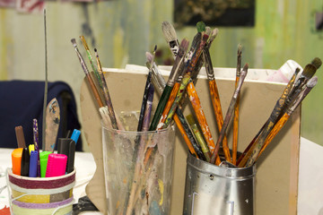 A set of brushes for paint of various sizes and with different bristles in glasses