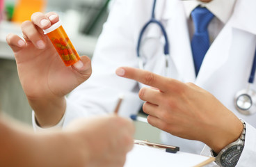 Close-up of doctor's hand holding medicine and giving it to his patient.