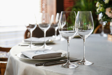 catering at a top event, glasses and flowers on the table, preparation for a significant event, beautiful dishes and glasses on the table, New Year's holiday table
