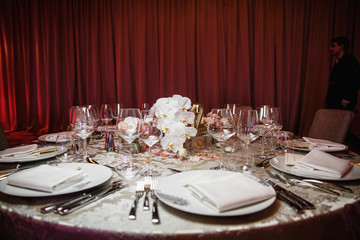 catering at a top event, glasses and flowers on the table, preparation for a significant event, beautiful dishes and glasses on the table, New Year's holiday table