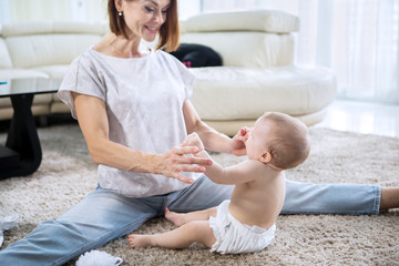 Caucasian mother playing with her baby on carpet