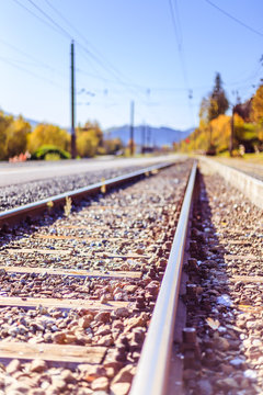Sustainable traveling by train: Rail track and colorful, idyllic landscape in fall.