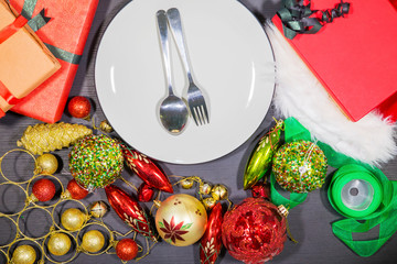Cutlery and plate with Christmas ornaments on table