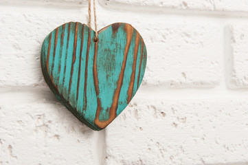 Wooden heart on a white brick wall background
