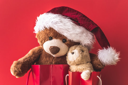 Christmas card with Teddy and banny in red gift bags.  With  holiday decoration and presents