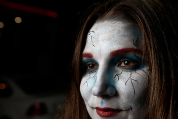 Half profile of mysterious charming young Caucasian female going to Halloween costume party, wearing bright artistic creative make up posing isolated with copy space for your advertising information