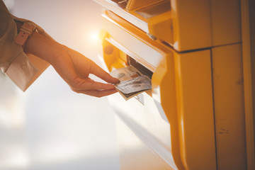 hand taking dollar bills out of an ATM