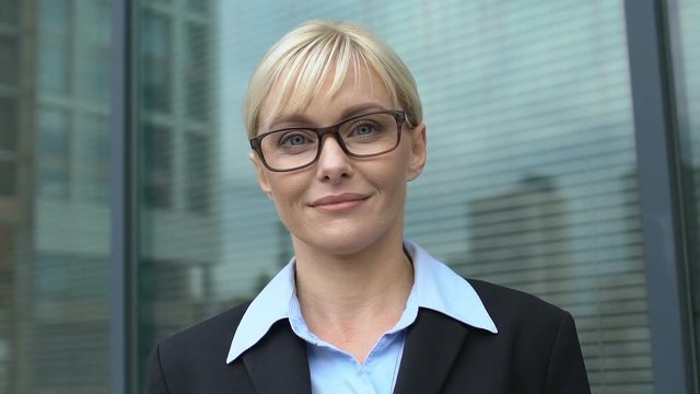 Confident woman in eyeglasses and suit looking to camera, lady boss portrait