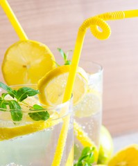 The glasss of mojito with lemon and drinking straw