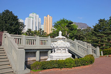 White lotus flower fountain in Nan Lian Garden near Chi Lin Nunnery with city skyscrappers in the background, Hong Kong .