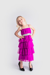 amazing girl in a blue retro dress and mother's patent leather high-heeled shoes smiling looks at the top. Isolated on a gray background.