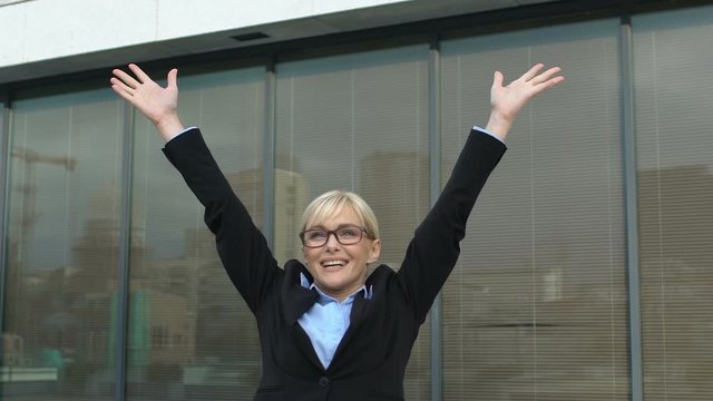 Successful business lady making winner gesture outdoors office building, freedom