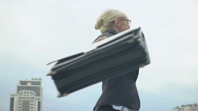 Cheerful businesswoman spinning and making winner gesture, successful deal