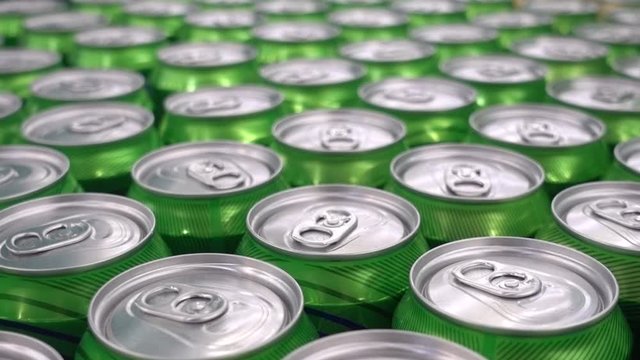 Green aluminum soda cans. Close up motion shot. Rows of aluminum cans.