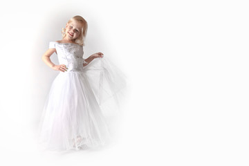 Fototapeta na wymiar little girl in a wedding dress. pretty little girl in beautiful white dress isolated on light background. Copy space