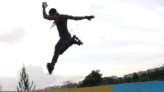 Young african man riding rollerblades on the ramp