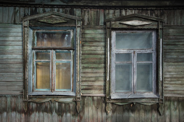 Two windows on the facade of an old wooden house. Voronezh, Russia.