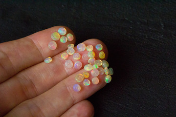 Opals gemstone Ethiopia lies black background. White fire opals with rainbowlike fire. Natural fire...
