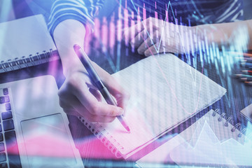 Financial chart drawn over hands taking notes background. Concept of research. Double exposure