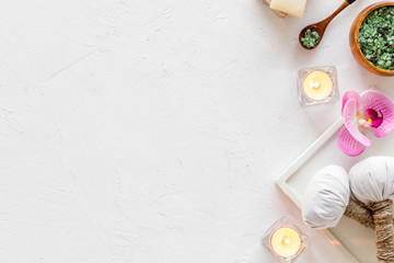 Preparing for massage in spa salon - with candles and orchids - white background top view frame copy space