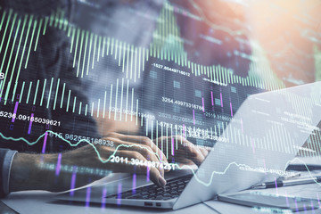 Double exposure of market chart with man working on computer on background. Concept of financial analysis.