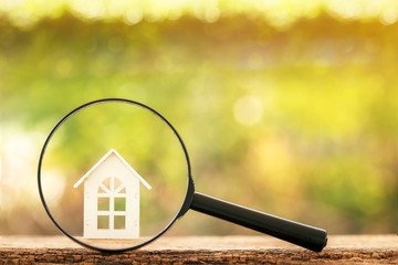 Magnifying glass with home model put on the wood on bokeh background, Loan for real estate and...