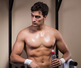 Naklejka premium Thirsty man drinking water in sports gym