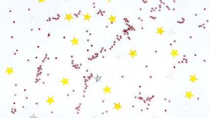 Christmas composition decoration. Pattern made of silver and gold star, golden decorations and red berries on white background.