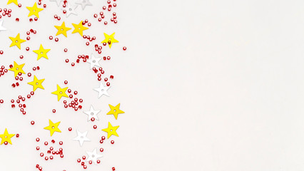 Christmas composition decoration. Pattern made of silver and gold star, golden decorations and red berries on white background.