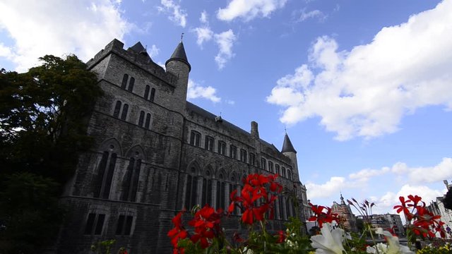 Ghent, Flanders, Belgium. August 2019. The graceful Castle Of Gerald the Devil. The flowers frame the castle. A hand enters the frame to indicate the castle.